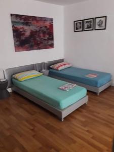 two twin beds in a room with wood floors at Spazio in Naples