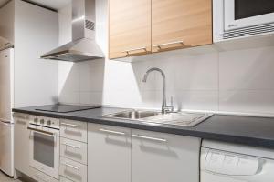 Biała kuchnia ze zlewem i kuchenką w obiekcie Apartamento Málaga Litoral Beach w Maladze