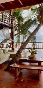 een woonkamer met een tafel en een palmboom bij Villa Naatang Bohol Beach House 1 in Jagna