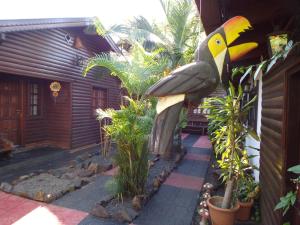 uma estátua de um pássaro ao lado de uma casa em Si Mi Capitán - Cabañas & Habitaciones em Puerto Iguazú