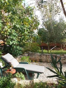 un banco sentado en medio de un jardín en House Kate, en Rovinj