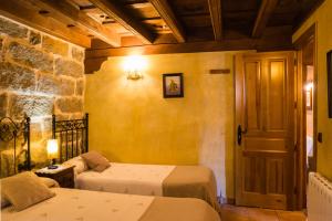 a bedroom with two beds in a room with a door at El Mirador del Alberche in Navaluenga