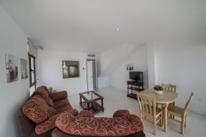 a living room with a couch and a table at Apartamentos Villas Flamenco Rentals in Conil de la Frontera