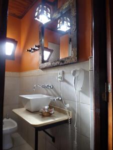 baño con lavabo y espejo en la pared en Si Mi Capitán - Cabañas & Habitaciones en Puerto Iguazú