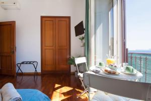 ナポリにあるNapoliCentro Mare - Sea View Rooms & Suitesのリビングルーム(テーブル、食器付)