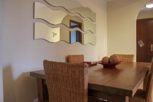 mesa de comedor con un espejo grande en la pared en (CAP001) Con jardín y acceso a la piscina., en Ayamonte