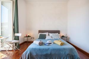 ナポリにあるNapoliCentro Mare - Sea View Rooms & Suitesのベッドルーム1室(ブルーベッド1台、タオル付)
