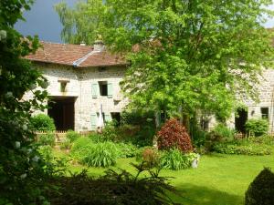 an old stone house with a garden in front of it at Yourtes de Vassivière in Peyrat-le-Château