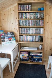 a book shelf filled with dvds next to a table at Wensleydale Glamping Pods in Redmire
