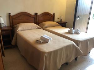 two beds in a hotel room with towels on them at Tenuta De Luca in Sannicandro Garganico