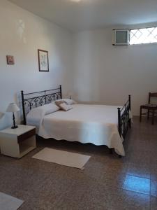 a bedroom with a large white bed and a window at CASA JUANNE iun P2043 in Galtellì