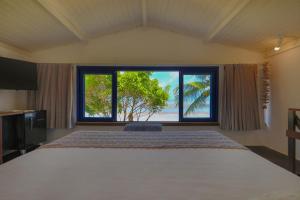 a bedroom with a large bed and a large window at Estalagem Caiuia in Japaratinga