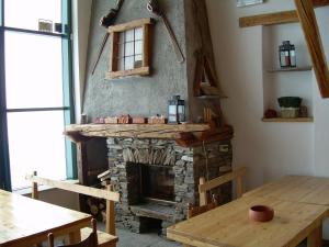 a living room with a fireplace and a table at Tana Della Volpe in Sestriere