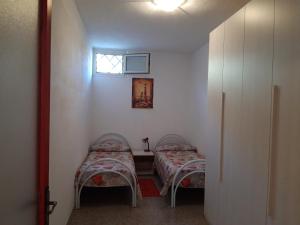 2 camas en una habitación pequeña con ventana en CASA JUANNE iun P2043, en Galtellì