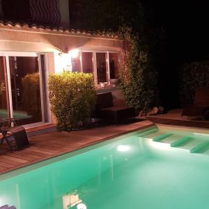 a swimming pool in front of a house at night at Le Mas de Marie in Grimaud