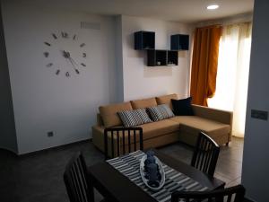 - un salon avec un canapé et un réveil sur le mur dans l'établissement Relax in costa Adeje, à Adeje
