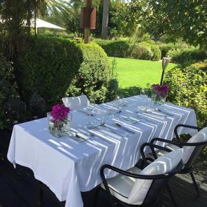 a long white table with chairs and flowers on it at Quinta da Lua in Tavira