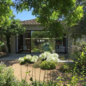 a garden with white flowers in front of a house at Quinta da Lua in Tavira
