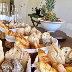 a table topped with baskets of bread and pastries at Quinta da Lua in Tavira