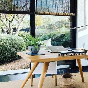 a wooden table with a laptop on it in front of a window at Quinta da Lua in Tavira