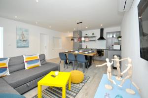 a living room with a gray couch and a table at Apartmani Olive Trogir in Trogir