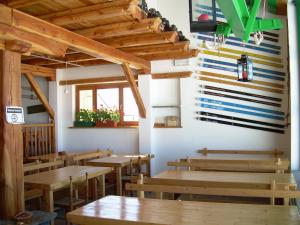 a restaurant with wooden tables and wooden ceilings at Tana Della Volpe in Sestriere