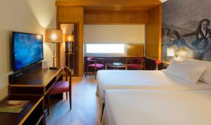 ein Hotelzimmer mit einem Bett und einem Flachbild-TV in der Unterkunft Hotel Goya in Saragossa