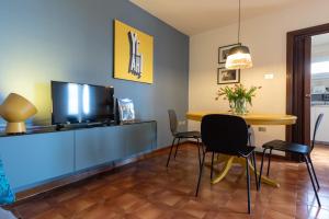 uma sala de jantar com uma mesa e uma televisão em Appartamento Tosca em Verona