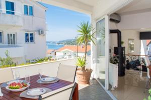 un balcone con tavolo e vista sull'oceano di Apartmani Kristina a Seget Vranjica