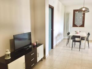 a living room with a television and a dining table at Residenza Leonardo in Porto SantʼElpidio