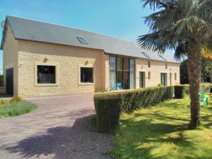 un edificio con una palmera delante de él en La Pomme Rouge, en Trévières