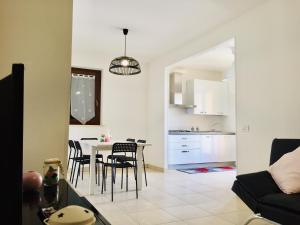 a living room and kitchen with a table and chairs at Residenza Leonardo in Porto SantʼElpidio