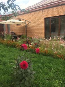 卡兹贝吉Story Guesthouse的砖砌建筑前种满鲜花的花园