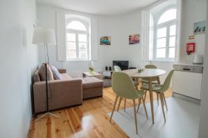 - un salon avec une table et un canapé dans l'établissement Passeio da Avenida - Central Avenue Apartment with Elevator, à Viana do Castelo