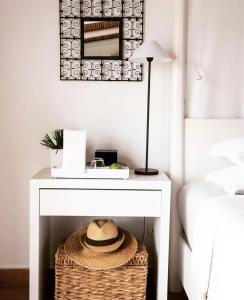 a bedside table with a basket and a lamp at Quinta da Lua in Tavira