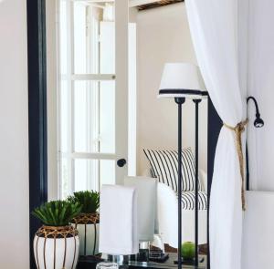 a room with a table with a lamp and vases at Quinta da Lua in Tavira