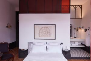 a hotel room with a white bed and white walls at Cocorico Luxury Guest House - Porto in Porto