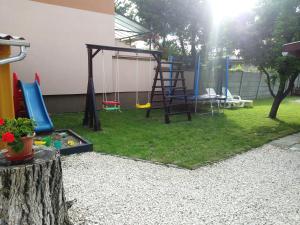 a backyard with a playground with a swing at Szivárvány Apartman in Gyula