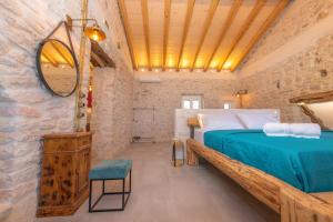 a bedroom with a bed in a stone wall at Ismini Kaminaki Beach in Nisakion