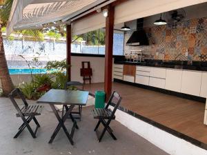 a patio with a table and chairs and a kitchen at Pousada da Pedra in Pedra de Guaratiba