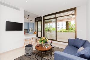 ein Wohnzimmer mit einem blauen Sofa und einem Tisch in der Unterkunft Gray d'Albion YourHostHelper in Cannes