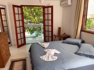 a bedroom with a bed with a dress on it at Pousada da Pedra in Pedra de Guaratiba +51 photos