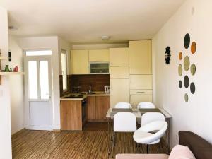 a kitchen with a table and some white chairs at Vila Jovana in Sutomore