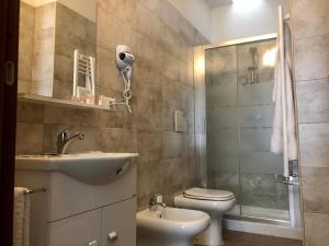 a bathroom with a sink and a toilet and a shower at La casa di Chloé in Alezio +33 photos
