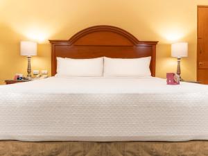 um quarto com uma grande cama branca e 2 candeeiros em Crowne Plaza Hotel Monterrey, an IHG Hotel em Monterrey