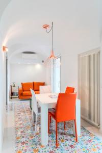 a dining room with a white table and orange chairs at The Lodge in Scala