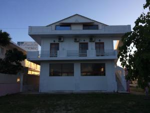 a white house with a balcony on the side of it at Hebes on the beach in Kavos