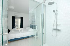 a bathroom with a glass shower and a bed at Apartmani Olive Trogir in Trogir +58 photos