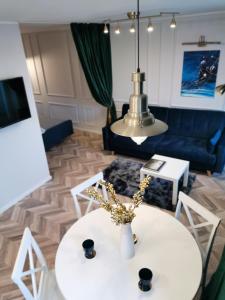 sala de estar con mesa blanca y sofá azul en Cosy center Apartment, en Klaipėda