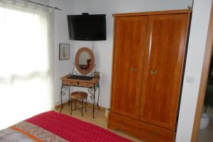 Schlafzimmer mit einem Bett, einer Kommode und einem Spiegel in der Unterkunft Bed and Breakfast La Petite Thielle in Cressier